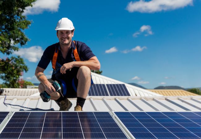 Foto de um homem instalando um painel solar.
