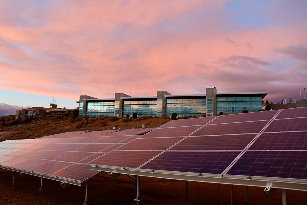 foto de painéis solares ao fundo de uma fábrica